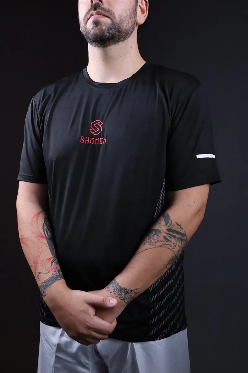 Atleta com a t-shirt técnica preta Shomen, com o logótipo bordado a vermelho no peito