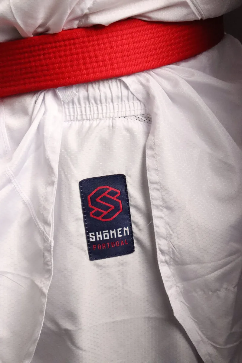 Cinto vermelho atado sobre o kimono Shomen, com a etiqueta Shomen Portugal