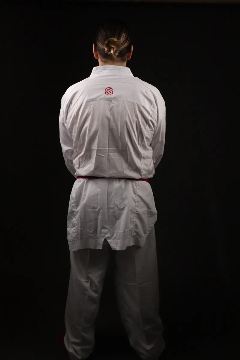 Atleta de costas com o kimono de kumite Shomen e cinto vermelho