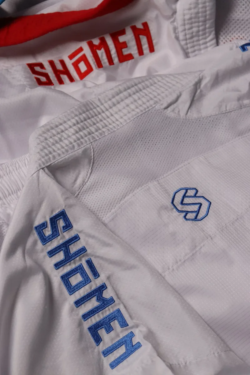 Pormenor das letras Shomen bordadas a azul na manga do kimono