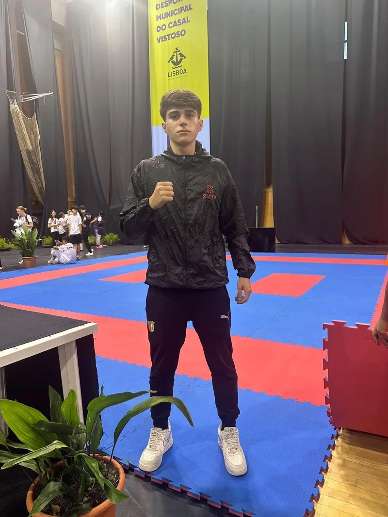 Martim Sá em cima do tatami, com o corta-vento Shomen e o punho levantado